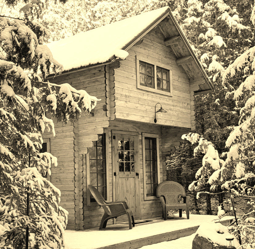 A cozy wooden cabin surrounded by snow-covered trees.
